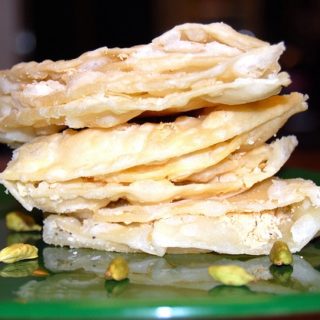 Chavde or mande, an Indian sweet, stacked on a green plate.