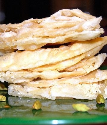 Chavde or mande, an Indian sweet, stacked on a green plate.