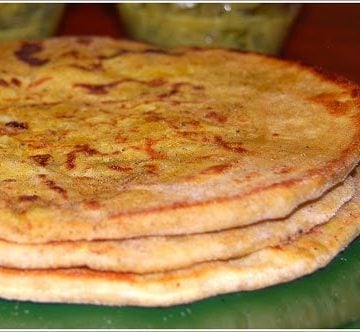 Trinidadian chickpea stuffed rotis stacked on green plate.