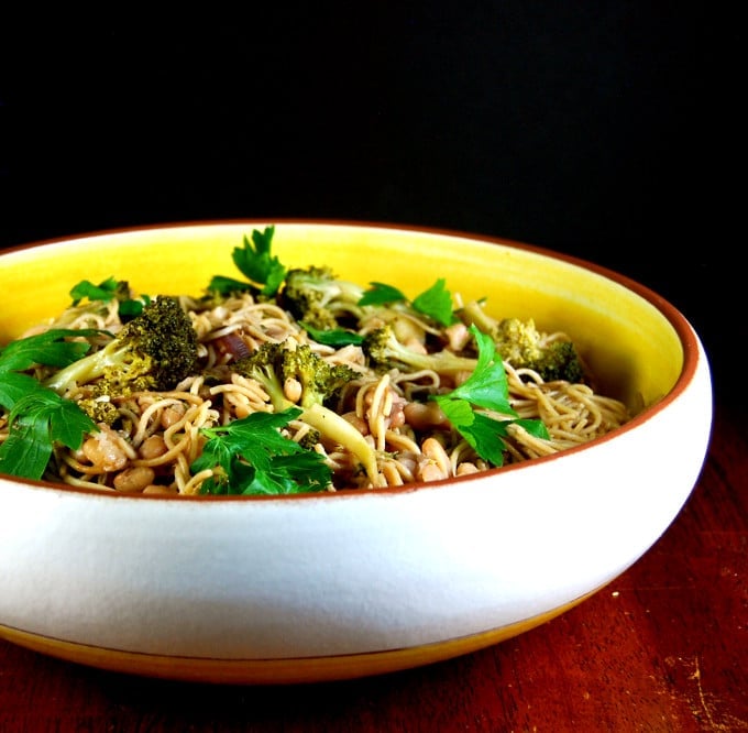 Pasta with Broccoli and Beans in yellow and white pasta bowl with a parsley garnish.