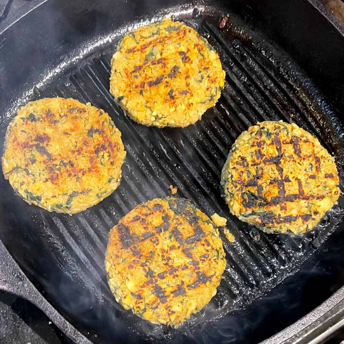 Chickpea quinoa burgers with cross hatch pattern on grill pan.