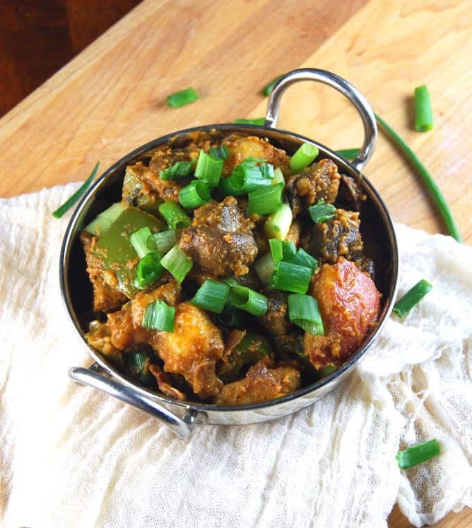Vegetable Balti in a steel karahi with scallions.