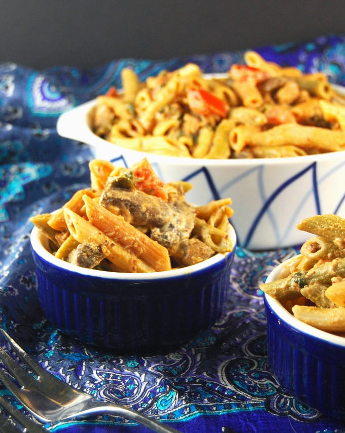 Pasta with Vegan Sausage and Greens in blue bowls and baking dish.