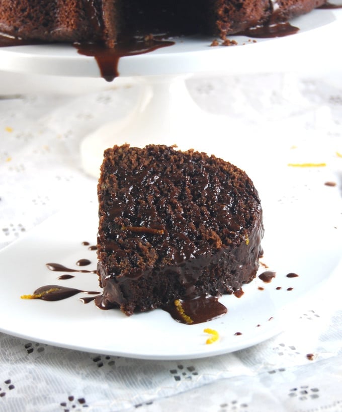 Front shot of a slice of vegan chocolate orange bundt cake on a white plate.