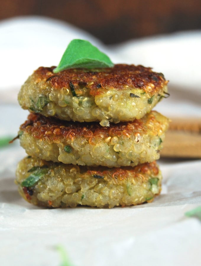 Garlicky Zucchini Quinoa Cakes stacked on parchment paper.