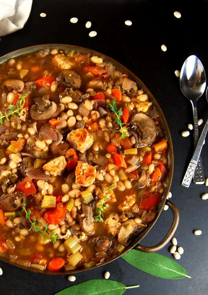 Photo of Vegan Cassoulet in a copper pan with sage and white beans. Glutenfree, healthy