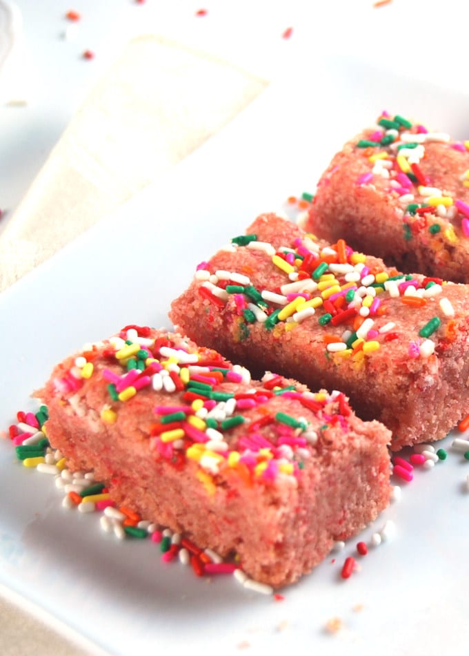 Pink Lemonade Cookie Bars with sprinkles on white rectangular plate.