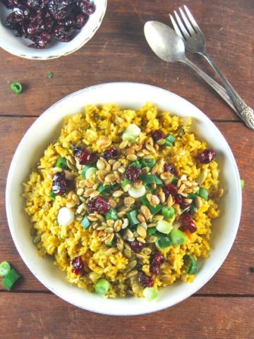 Pumpkin Biryani topped with candied cranberries and pumpkin seeds. A vegan and gluten-free recipe.