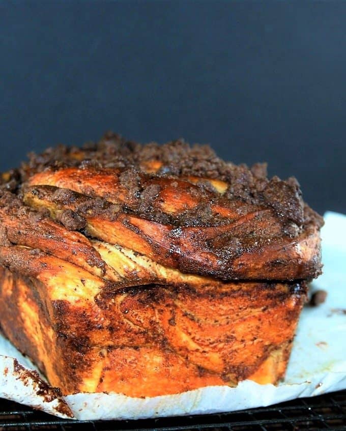 A side shot of a golden-brown loaf of Vegan Chocolate Babka