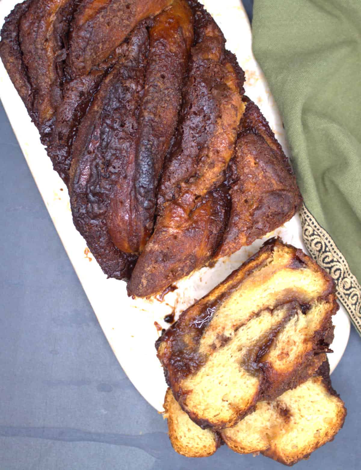 Sliced vegan chocolate babka loaf on marble board.