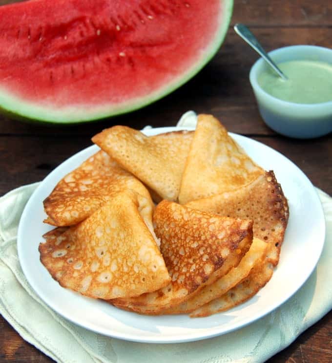 Watermelon Rind Dosa in white plate with chutney and a slice of watermelon.