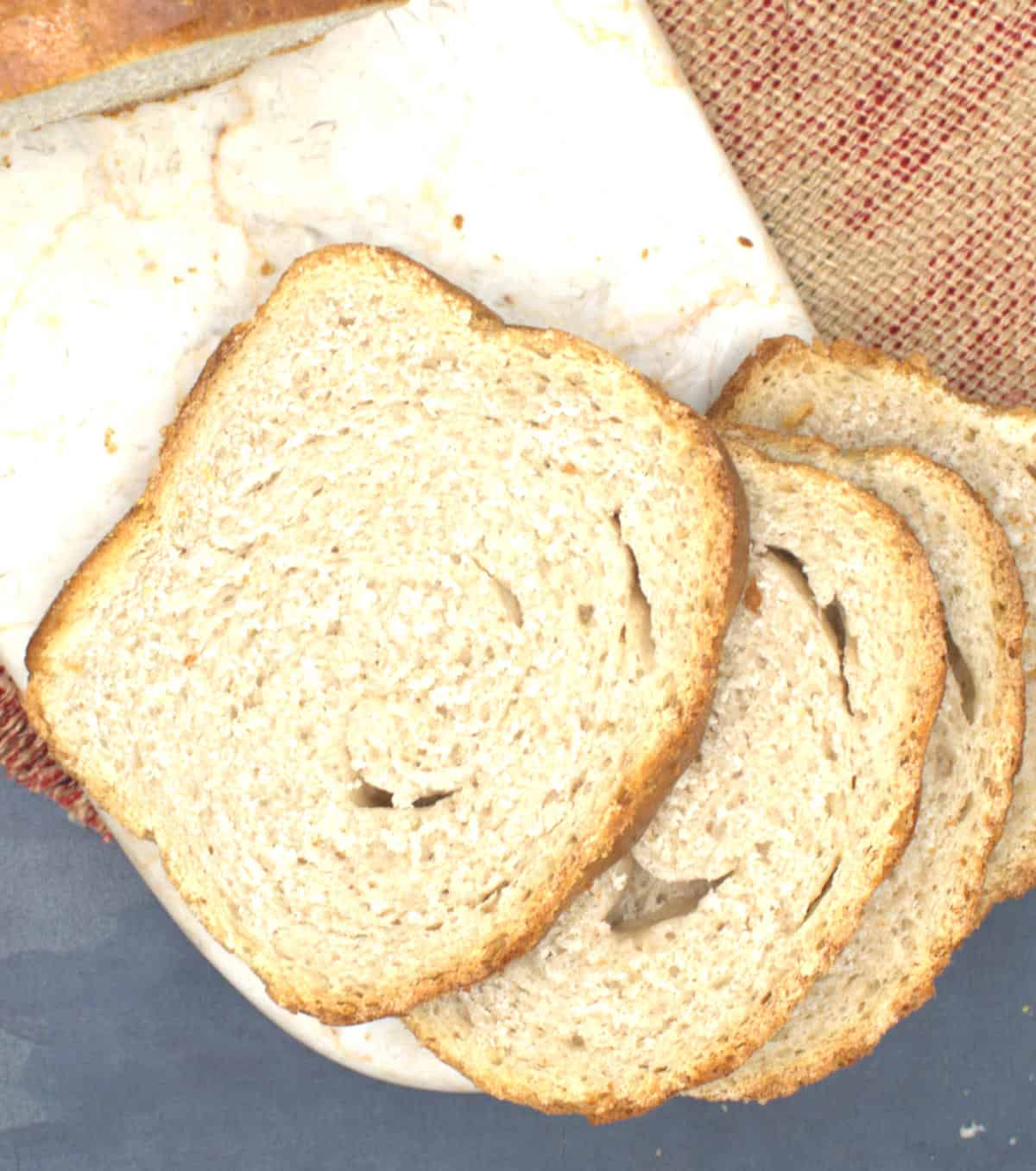 Slices of sourdough sandwich bread on marble board.