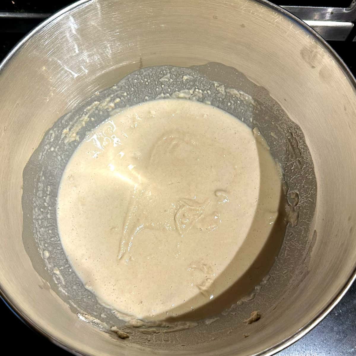 Sourdough starter, water and flour mixed in stand mixer bowl.