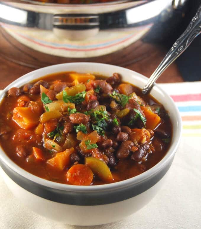 Vegan Three Bean Chili with Fall Veggies in a black and white bowl.
