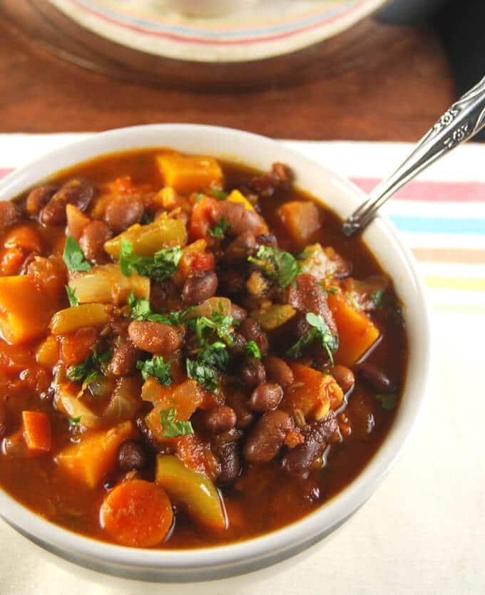 Vegan Three Bean Chili with Fall Veggies in a black and white bowl.