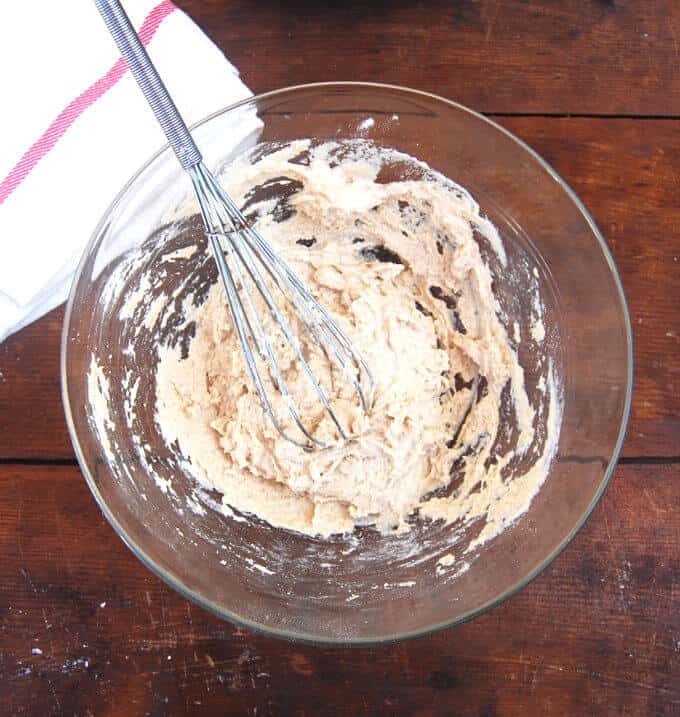 Photo of flour and water whisked together in a glass bowl to begin a sourdough starter.
