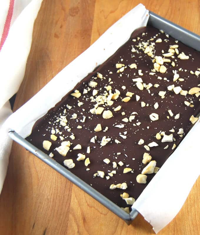 No Bake Vegan Chocolate Cheesecake Bars in baking pan lined with parchment paper.
