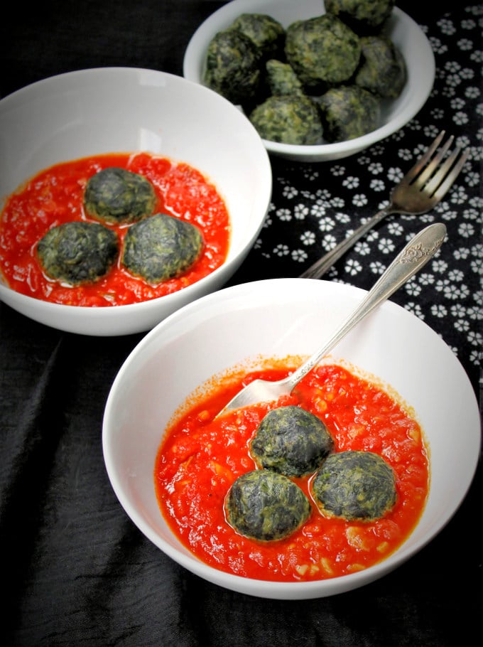 Spinach Cashew Ricotta Dumplings in a Marinara Sauce served in two white bowls with forks.