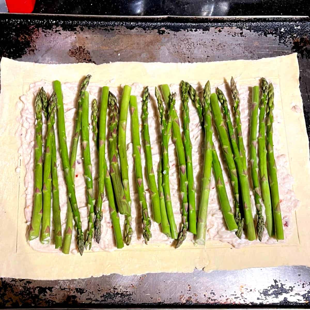 Asparagus spears layered on puff pastry crust.