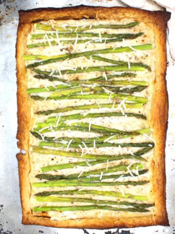 Vegan asparagus pizza on baking sheet.