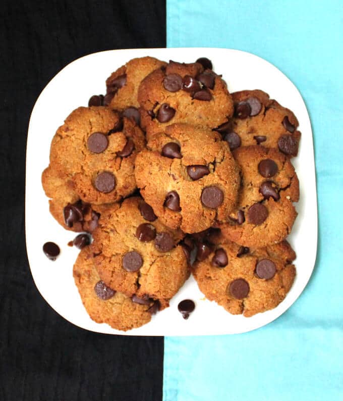 Photo of grain free chocolate chip cookies stacked on a white plate.