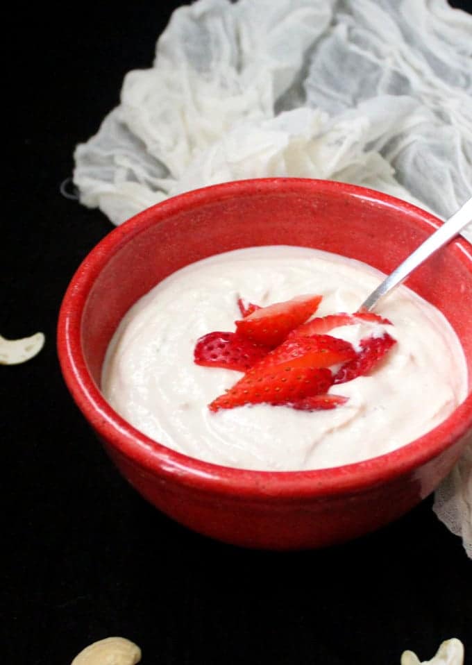 Vegan Cashew Yogurt with strawberries in a red bowl.