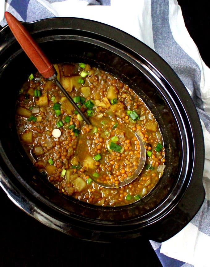 Slow Cooker Butternut Squash Dal in crockpot liner with soup ladle.