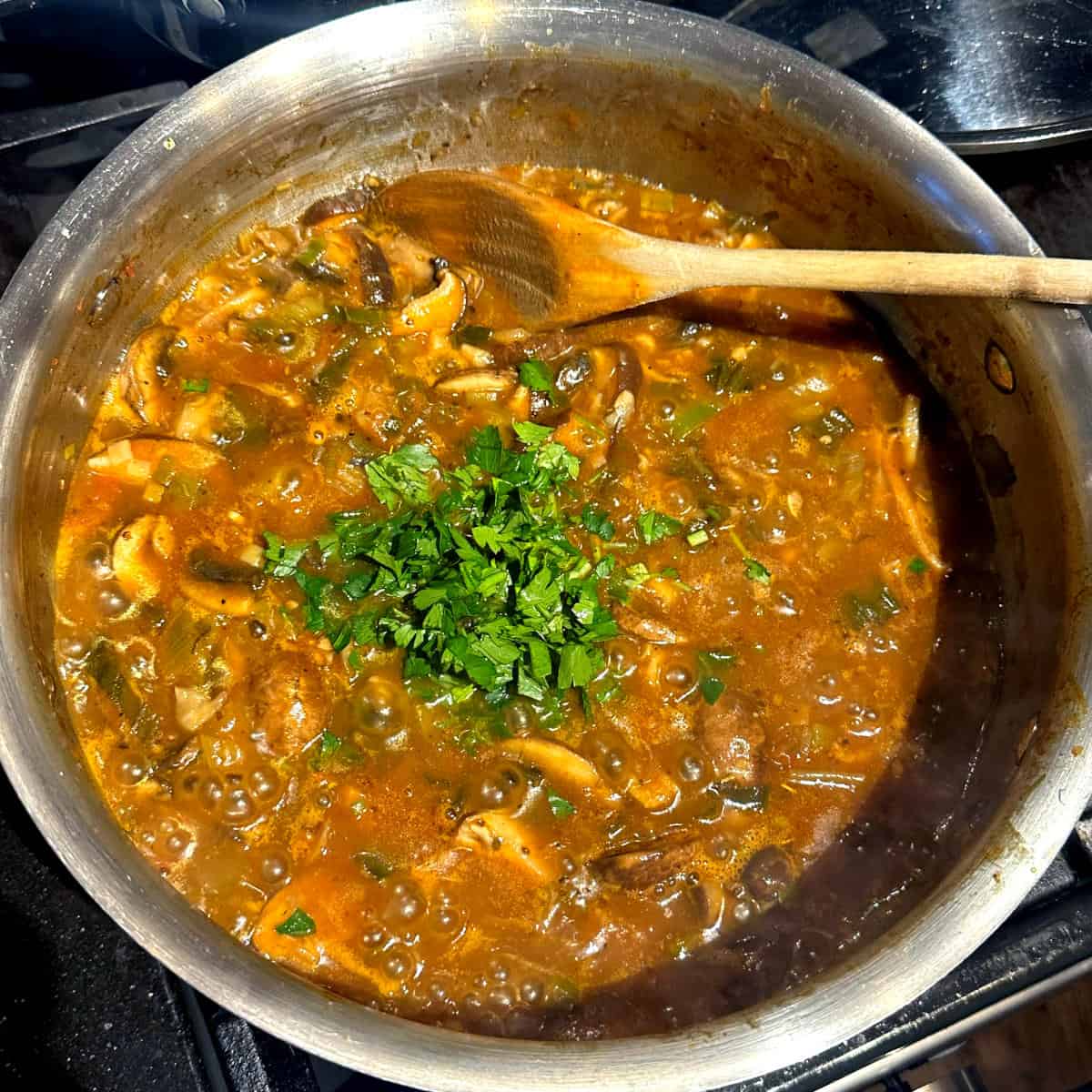 Parsley added to cooked mushroom stew.