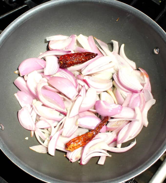 Onions and chili peppers in wok.