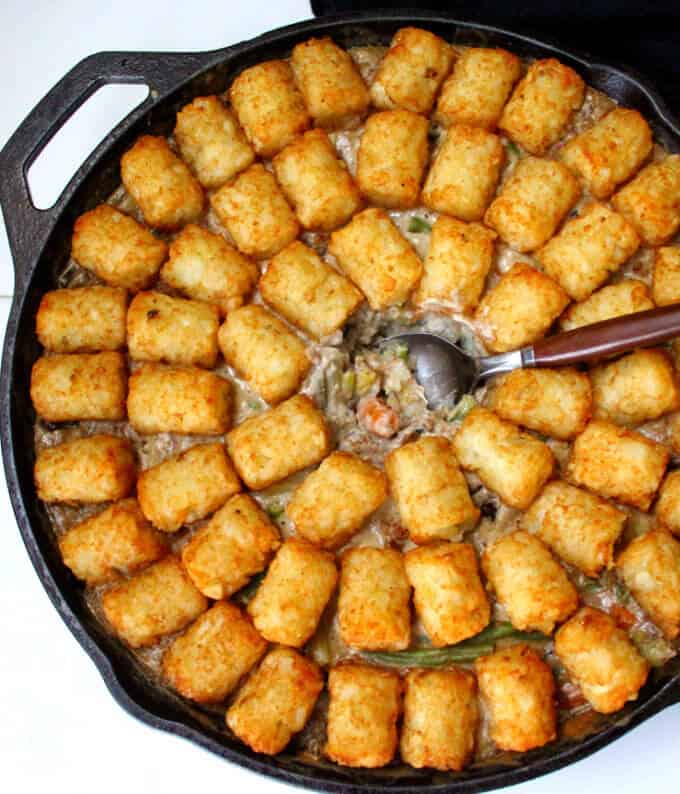 Vegan tater tot casserole with the filling inside showing.