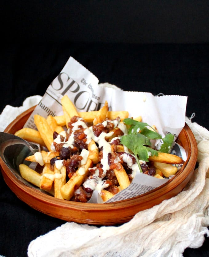 A frontal shot of a bowl of Vegan Chili Fries with cheezy horseradish sauce - HolyCowVegan.net