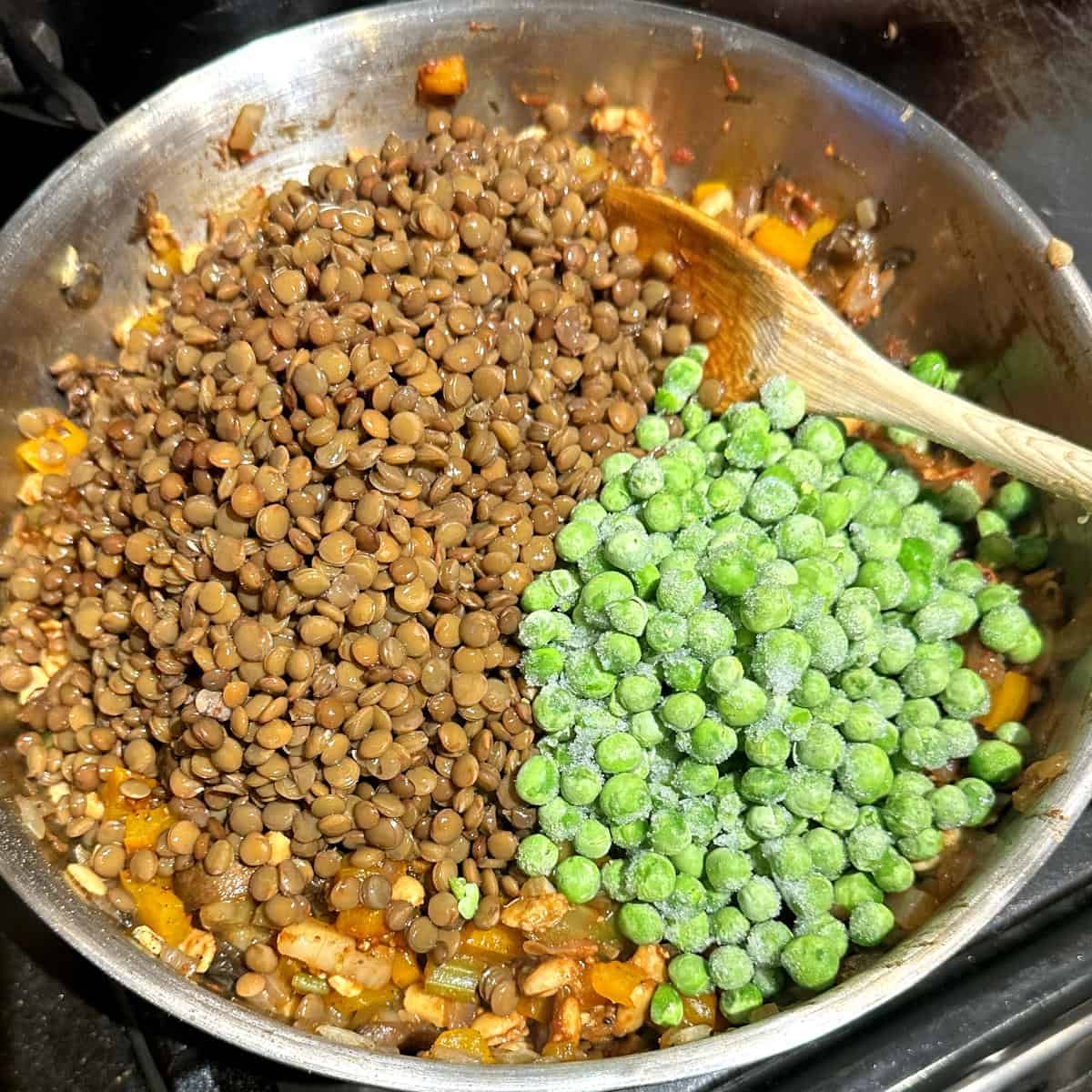 Lentils and peas added to skillet.