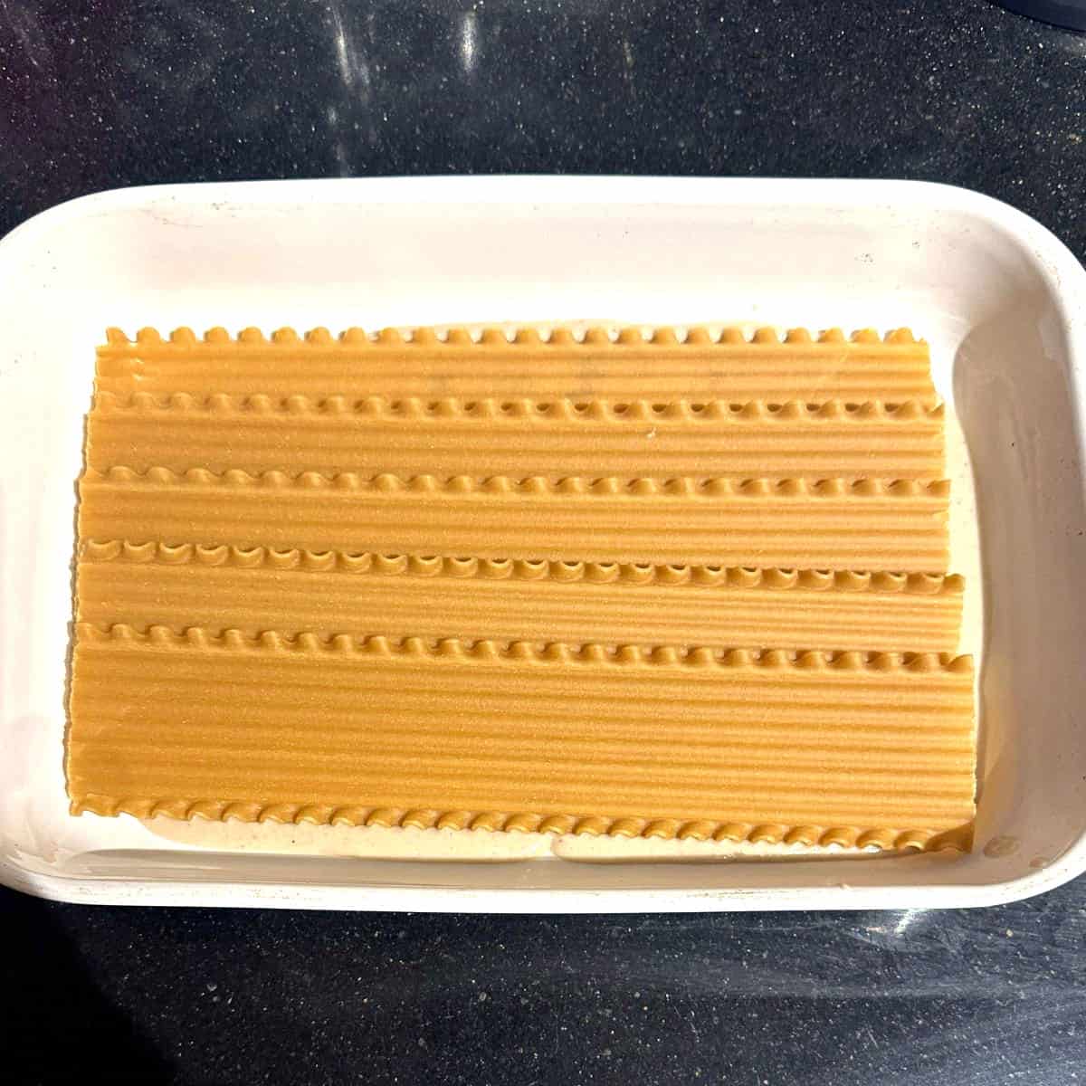 Lasagna noodles in bottom of pan over vegan bechamel.