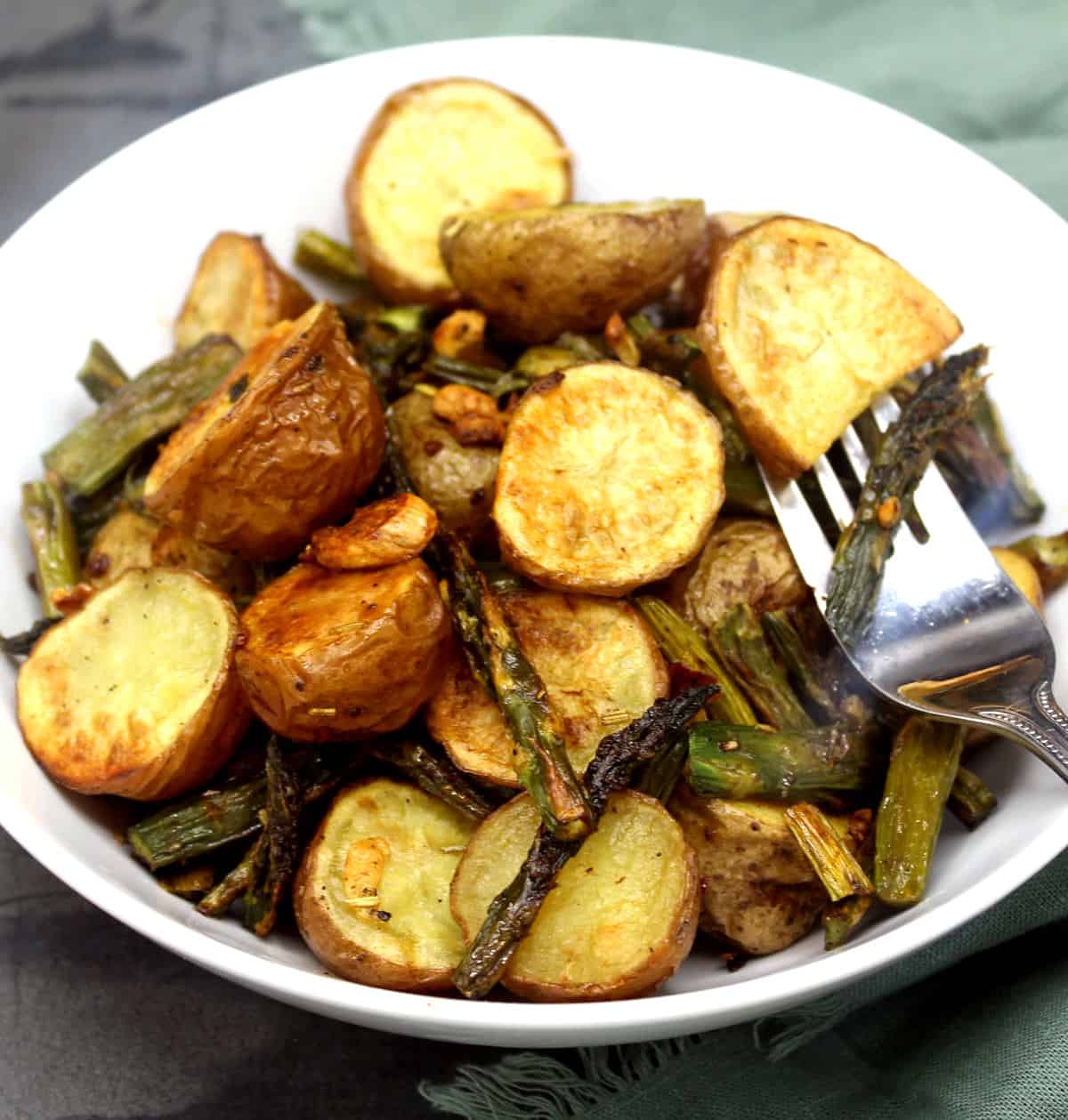 Garlicky roasted asparagus and potatoes in bowl.
