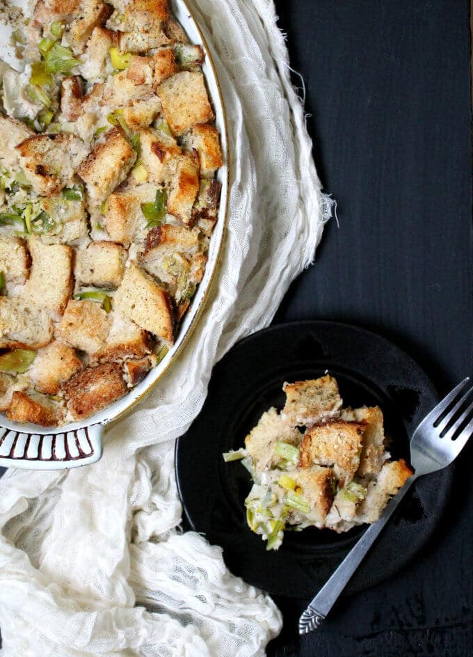 Vegan Leek and Sourdough Bread Pudding in plate and baking dish.