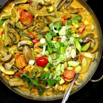 20-minute veg curry in a copper pan with tomatoes, mushrooms, bell peppers and scallions