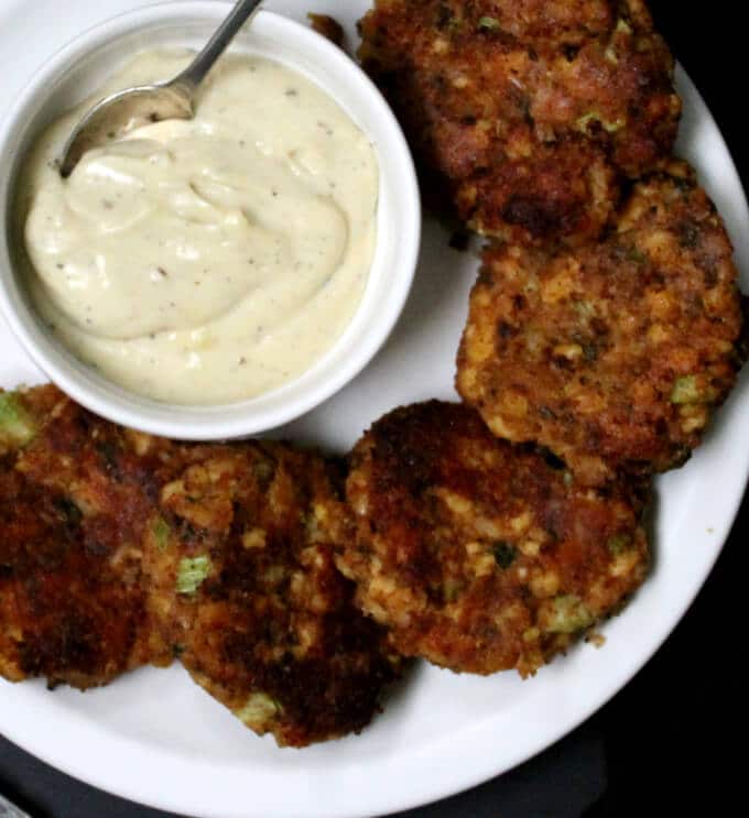 Vegan Maryland Crab Cakes in plate with white sauce in bowl.