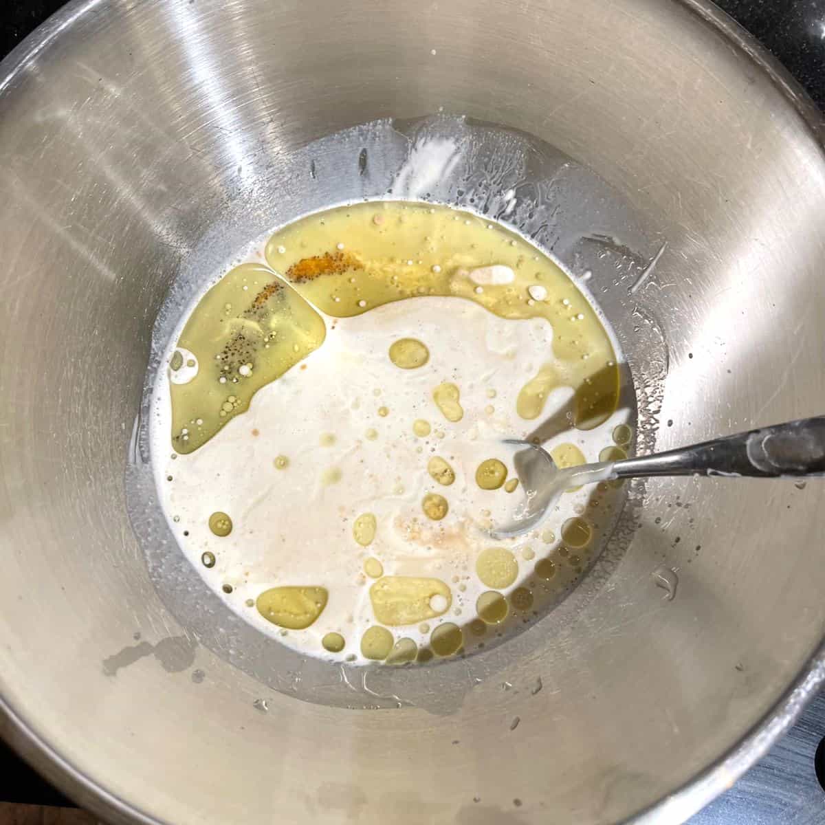 Sourdough starter, oil and other ingredients in bowl.