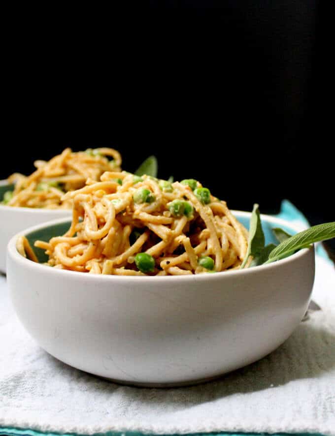 This creamy, delicious Tahini Butternut Squash Pasta will be a hit at your dinner table. Roasted butternut cubes are blended with tahini into a smooth sauce and spiked with smoky sage. Green peas add sweetness, flavor and texture. Make with whole wheat pasta or gluten-free pasta. A vegan, soy-free and nut-free recipe. Sauce is gluten-free. #vegan #soyfree #nutfree #glutenfree #pasta HolyCowVegan.net