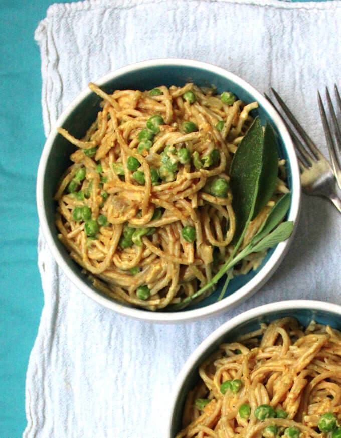 This creamy, delicious Tahini Butternut Squash Pasta will be a hit at your dinner table. Roasted butternut cubes are blended with tahini into a smooth sauce and spiked with smoky sage. Green peas add sweetness, flavor and texture. Make with whole wheat pasta or gluten-free pasta. A vegan, soy-free and nut-free recipe. Sauce is gluten-free. #vegan #soyfree #nutfree #glutenfree #pasta HolyCowVegan.net