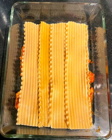 Lasagna noodles layered in baking pan.