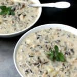 Vegan mushroom wild rice bisque in two bowls with spoons.
