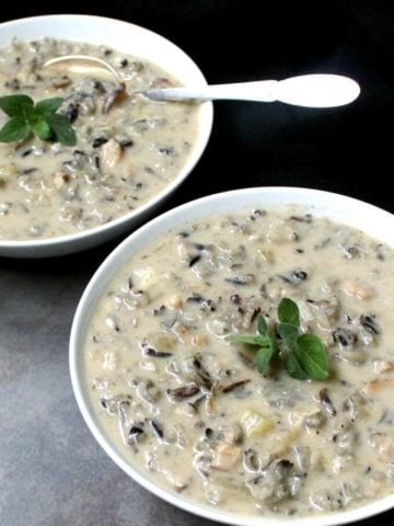 Vegan mushroom wild rice bisque in two bowls with spoons.