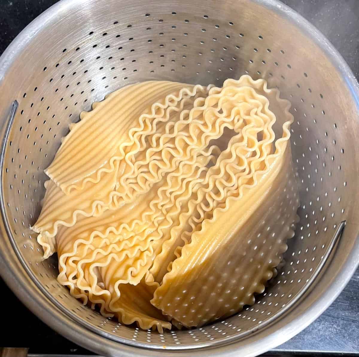 Lasagna noodles cooked and drained in colander.