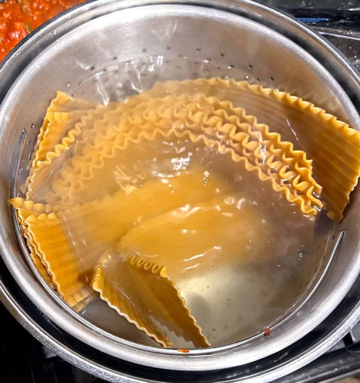 Lasagna noodles cooking in water.