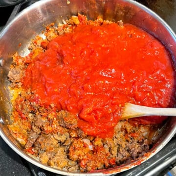 San marzano tomatoes added to vegan meats in saute pan.