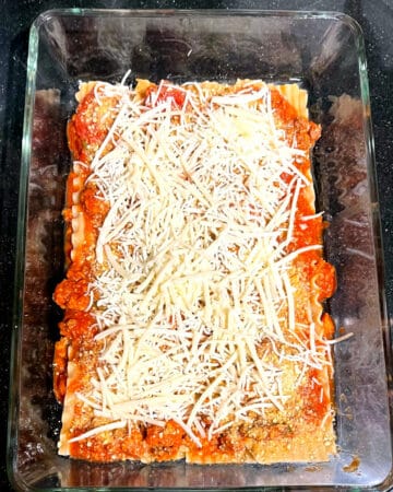 Vegan mozzarella layered over tomato sauce.