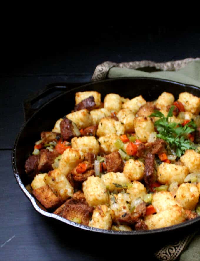 The secret to my perfect Vegan Thanksgiving Stuffing is crunchy, crispy tater tots. This traditional holiday staple gets a fresh, new makeover in a recipe that's as easy and fun to make as it is delicious to eat. Vegan, nut-free, soy-free and can be gluten-free. #vegan #soyfree #nutfree #thanksgiving #sidedish #stuffing HolyCowVegan.net