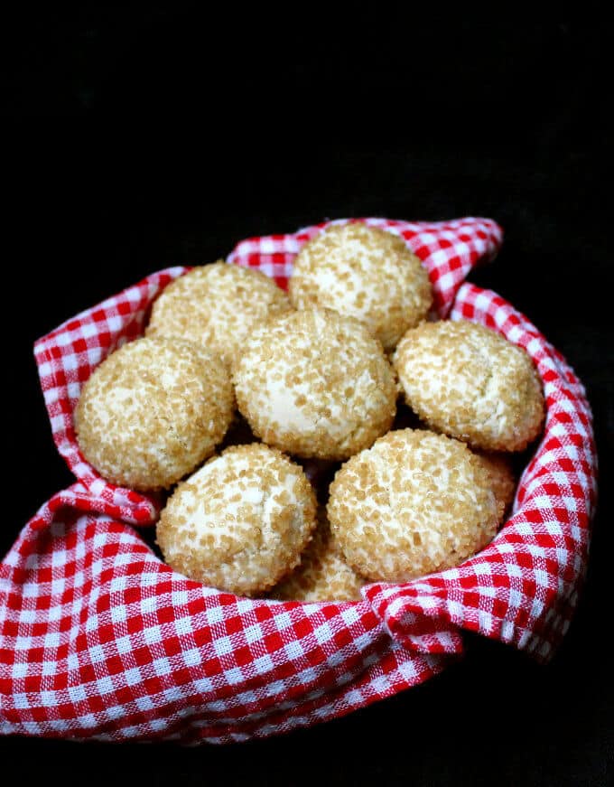 Amaretti cookies nestled in a red and white napkin against a black background
