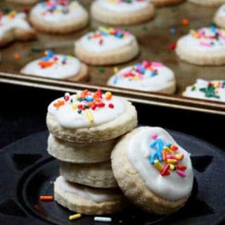 These gluten-free and vegan Sugar Cookies are tender and delicious with a fluffy buttercream-like frosting. Make these a part of your holiday cookie platter. #vegan #soyfree #glutenfree #cookies #recipe #holidays HolyCowVegan.net